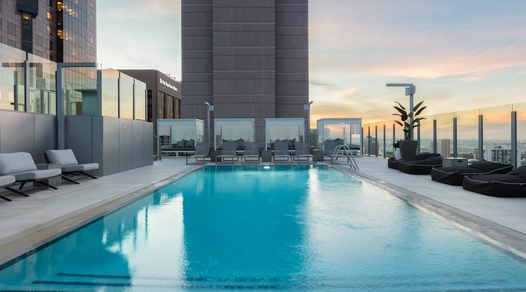 swimming pool with lounge chairs and a city in the background