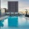 swimming pool with lounge chairs and a city in the background