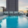 swimming pool with lounge chairs and a city in the background